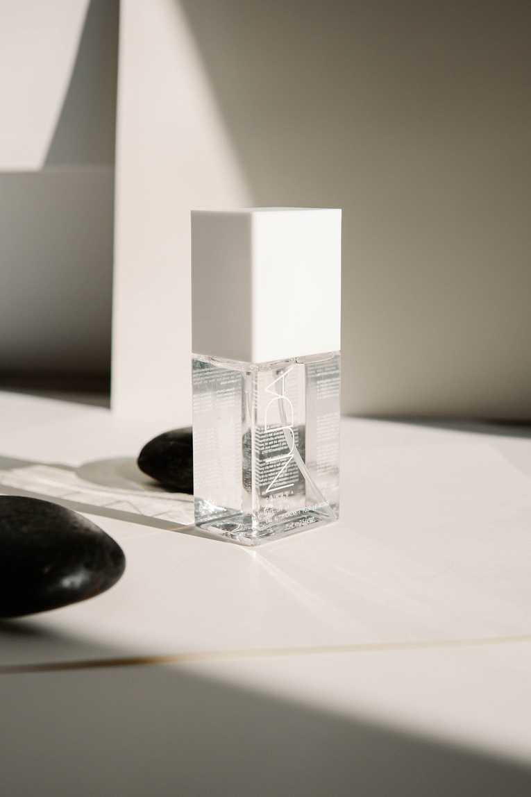 Clear Glass Perfume Bottle on White Table